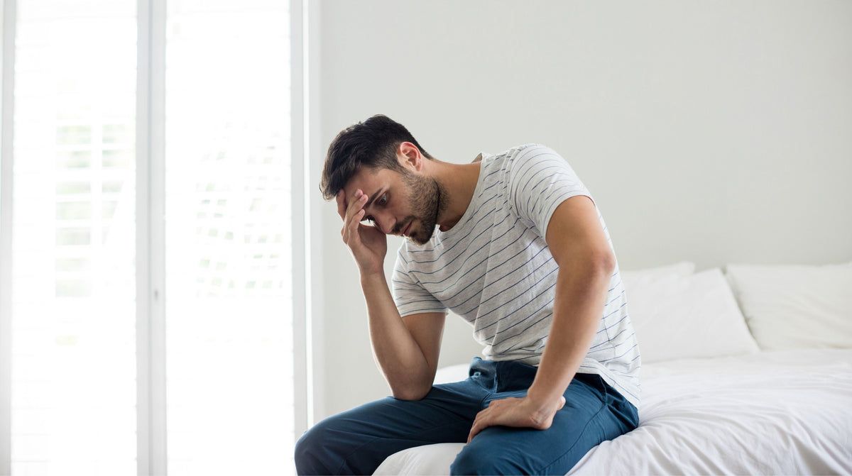 Worried man sitting in bed